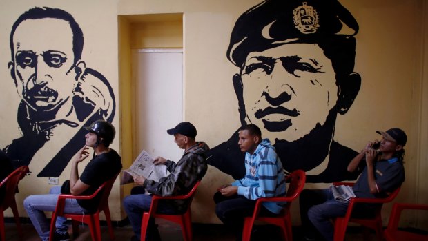Voters at a Caracas polling station wait to cast their ballots next to murals of Venezuelan Independence hero Ezequiel Zamora and the late Venezuelan President Hugo Chavez.