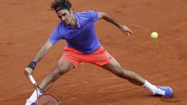 Roger Federer stretches to effect a return to Alejandro Falla of Colombia during their first-round match on Sunday.
