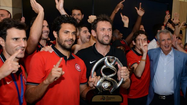 Back home: Wanderers' coach Tony Popovic with the AFC Champions trophy at Sydney airport on Monday night.