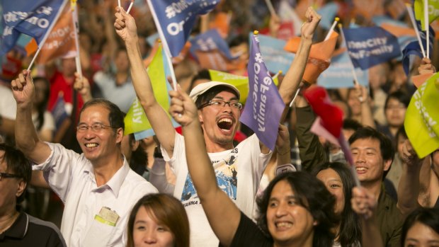 Supporters of independent opposition candidate Ko Wen-je celebrate after he won the mayoral elections for Taipei, part of a landslide defeat for Taiwan's ruling Kuomintang party.