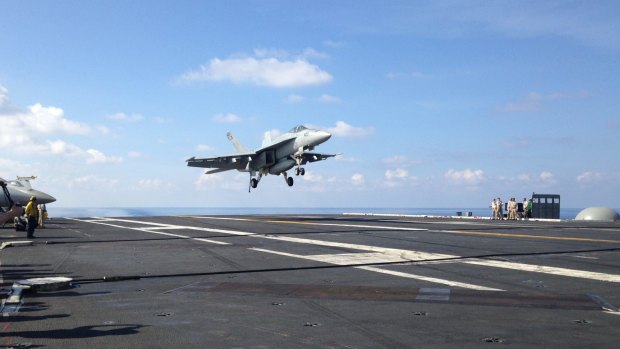 An FA-18 jet fighter lands on the USS John C. Stennis, aircraft carrier in the South China Sea on Friday. 