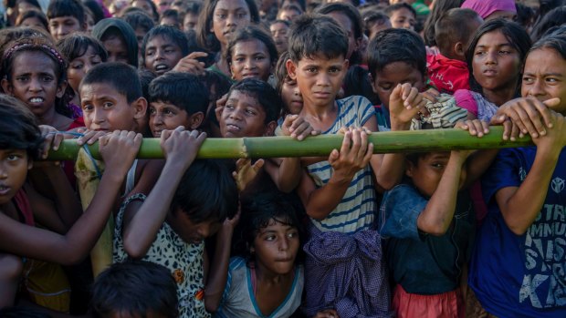Rohingya Muslim children, who crossed over from Myanmar into Bangladesh, wait to receive aid during a distribution near Balukhali refugee camp, Bangladesh
