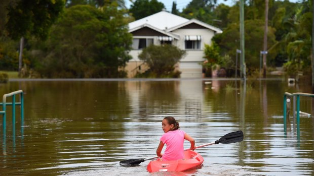 Maleah Jones, 8, canoes up flooded Bright street to her home in Lismore.  