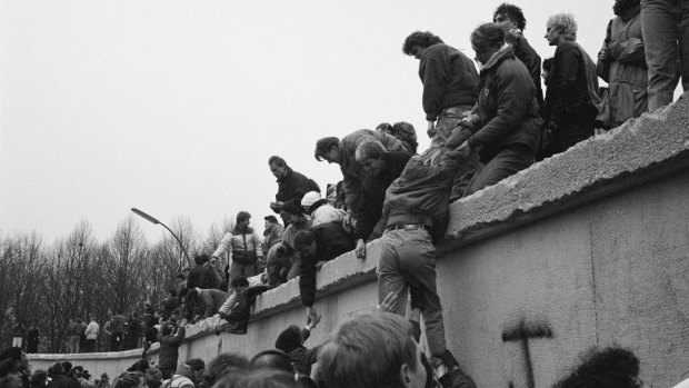 East Berliners climb onto the Berlin Wall to celebrate the effective end of the city's partition on December 31, 1989.
