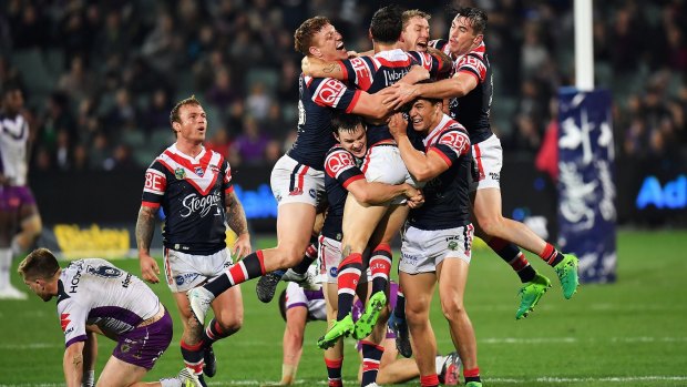 Roosters' Mitchell Pearce celebrates with teammates after the golden point win.