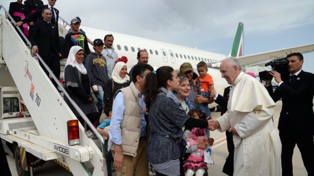 Pope Francis greets a group of Syrian refugees upon landing at Rome's Ciampino airport.