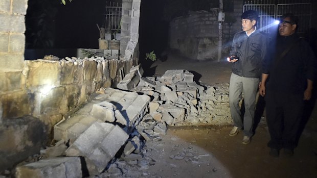 Spot checks: In this photo released by China's Xinhua News Agency, villagers check the damaged house at Mangla Village of Yongping.