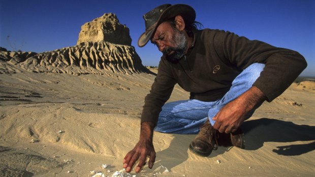 A guide points out partially buried bones in Mungo National Park.