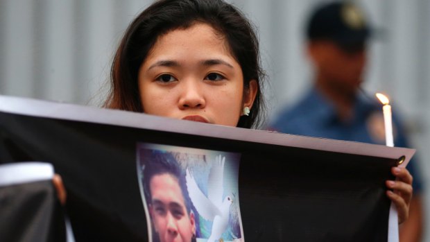 A protester displays a portrait of slain Kian Loyd delos Santos, a 17-year-old student, who was killed by Philippine police in August.