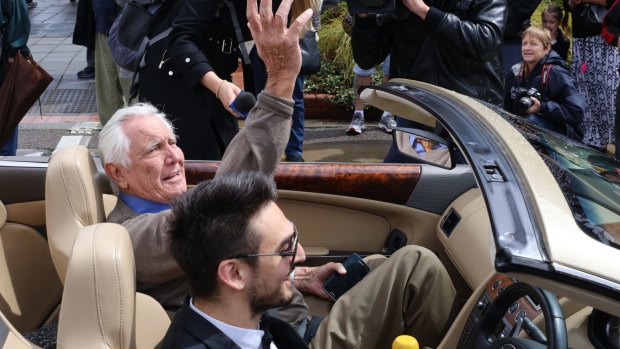 Australia's only James Bond, George Lazenby, waves to fans during the SpyFest Street Parade on Saturday.