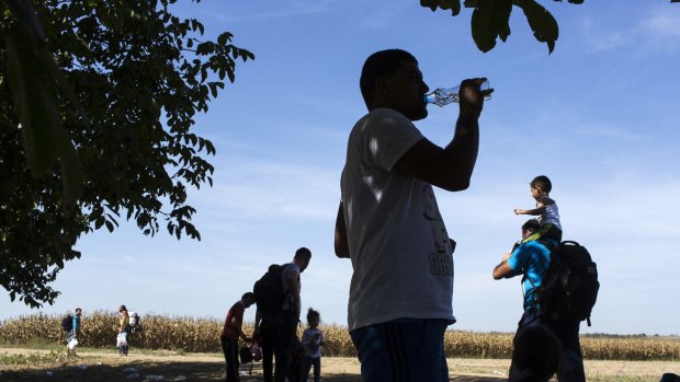 Refugees stop for a break during the midday heat on their way to the border crossing from Serbia into Tovarnik, Croatia, on Thursday.