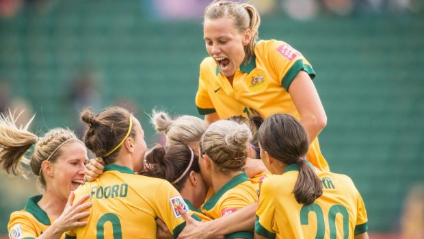 Matildas midfielder Emily van Egmond (top) joins the celebrations for captain Lisa de Vanna's goal against Sweden in Edmonton in the Women's World Cup