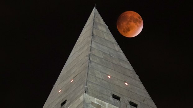 The supermoon passes behind the peak of the Washington Monument during a lunar eclipse on Sunday.