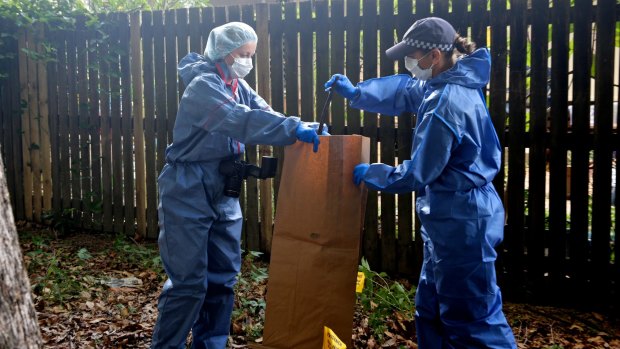 Police collect metal bar from the park next to the home where eight children were killed.