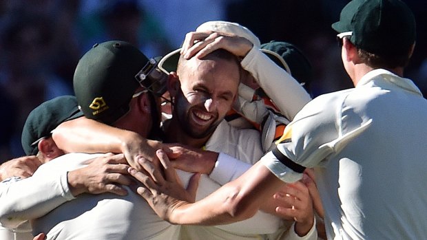 Nathan Lyon is mobbed by Australian teammates after bowling his side to victory against India in Adelaide.