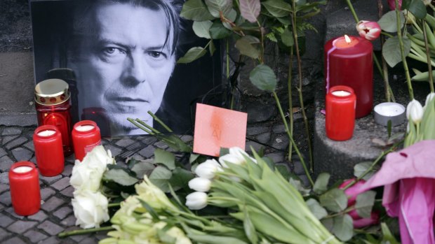 Flowers and a portrait are placed in front of the apartment building where David Bowie once lived in Berlin, Germany, 