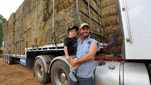 Stanbridge farmer Brendan Farrell with his son, Sam, and some of the hay bales to be transported.