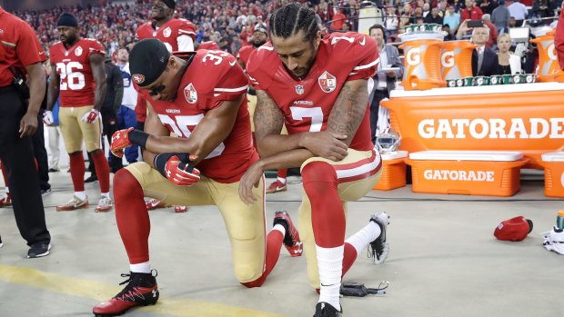 San Francisco 49ers safety Eric Reid and quarterback Colin Kaepernick kneel during the national anthem.