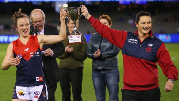 Best-on-ground Daisy Pearce and Melbourne coach Michelle Cowan hold up the trophy.