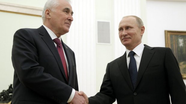 Russian President Vladimir Putin and South Ossetia leader Leonid Tibilov shake hands in Moscow.