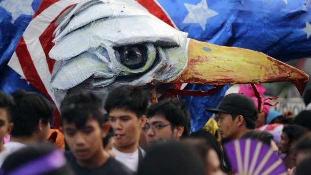 Activists stand beside an effigy of an eagle dressed with a US flag outside the Presidential palace.