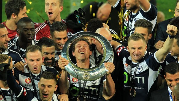 Melbourne Victory captain Mark Milligan (centre) savours their grand final triumph with his teammates.