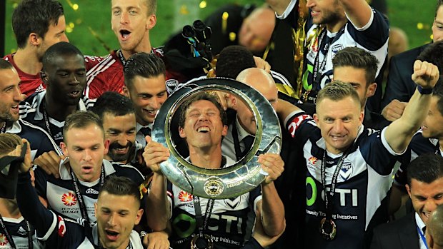 Melbourne Victory captain Mark Milligan (centre) savours their grand final triumph with his teammates.