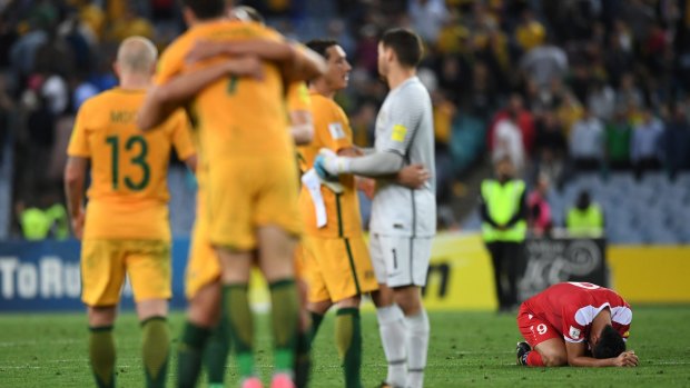 Syria's Omar Alsoma (right) kneels on the pitch after they lost the 2018 World Cup qualifying football match to Australia in Sydney on October 10.