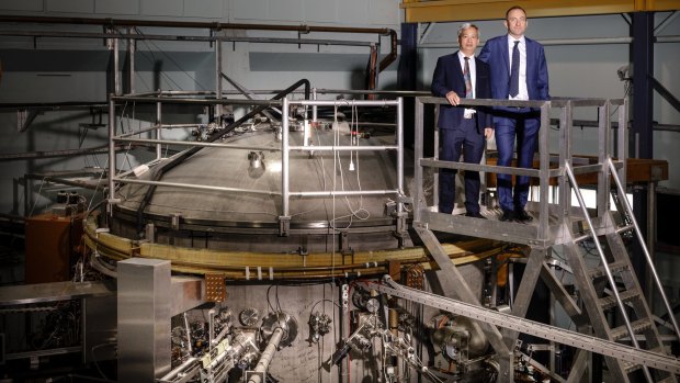Director of the Australian Plasma Fusion Research Facility at ANU Dr Cormac Corr, right, standing with University of South China Professor Zhao Li Hong beside the 25 tonne H1 Heliac stellarator.