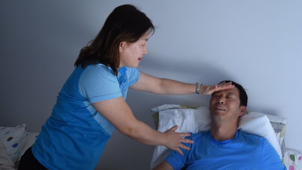 In-Young Joyce helps her husband Myung Jin Juong at their home in Epping. 