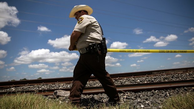 A county law enforcement officer establishes a perimeter around the site where the hot air balloon crashed.