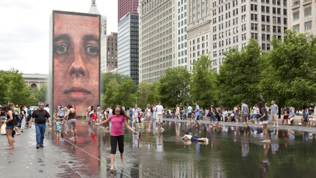 Children play in water of the Crown Fountain in Millennium Park in downtown Chicago.