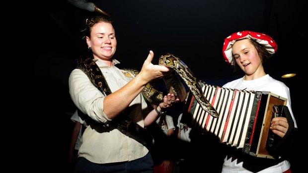 National Zoo and Aquarium senior wildlife keeper Renee Osterloh with Burnie the Burmese Python and Tilda Blackbourn-Rooney from Wild Voices Music Theatre who will perform at the zoo during Enlighten.