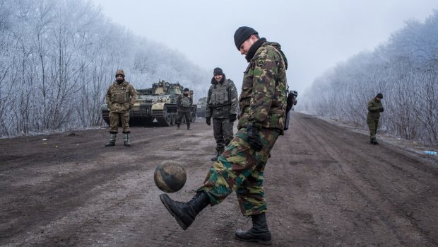 Ukrainian soldiers play football on the road leading to the embattled town of Debaltseve. The Ukrainian forces say they have been shelled regularly by Russian troops in Russia.