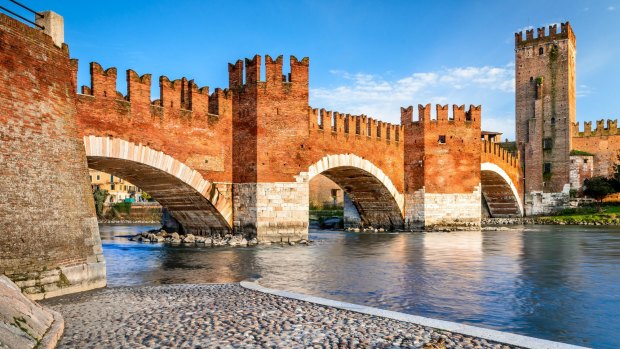 The Adige River in Verona with medieval landmarks Ponte Scaligero and Castelvecchio.