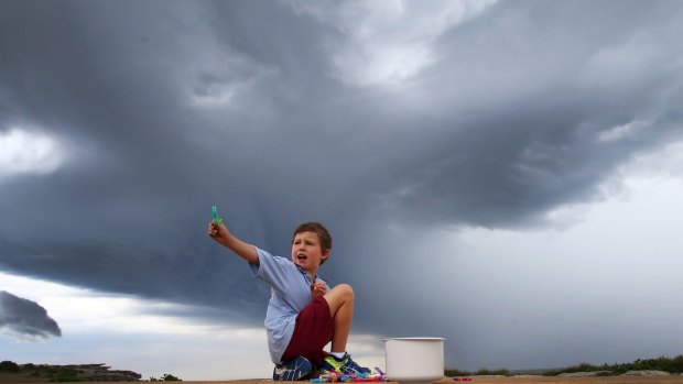 A child plays as a storm rolls in over Clovelly.
