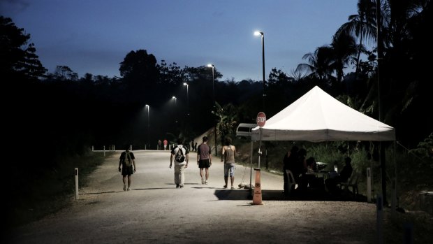 Refugees pass a security check point on Manus Island.