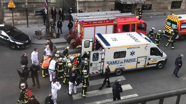 An unidentified wounded person is taken into an ambulance outside the Louvre in Paris on Friday.