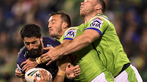 Close encounter: Storm prop Jesse Bromwich is tackled by Raiders hooker Josh Hodgson.