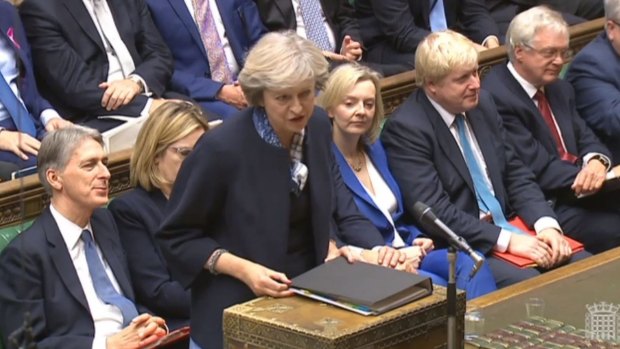Britain's Prime Minister Theresa May, centre, stands to answer a question during Prime Minister's question time in the Commons.