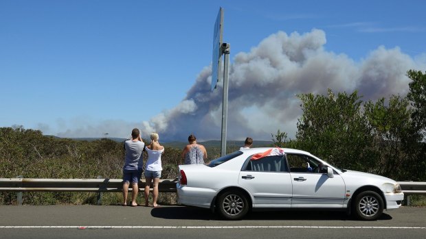 Onlookers watch as a bushfire burns in the Royal National Park.