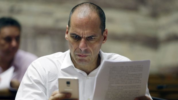 Yanis Varoufakis, now just a member of Greek parliament, checks his cell phone before a meeting.