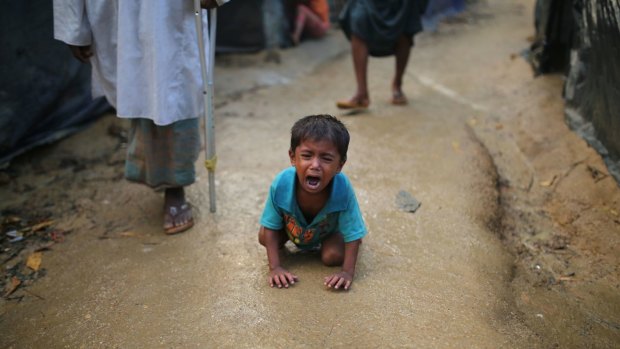 A Rohingya child cries on the ground at a makeshift refugee camp in Bangladesh. Children have given harrowing accounts of violence in Myanmar.