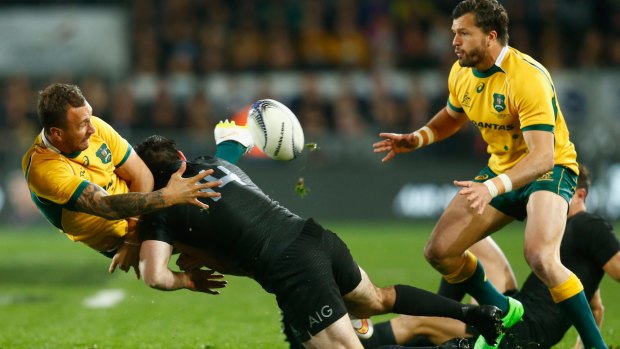 Lure of the green and gold: Quade Cooper offloads to Adam Ashley-Cooper during the Bledisloe Cup match with the All Blacks at Eden Park in August last year.