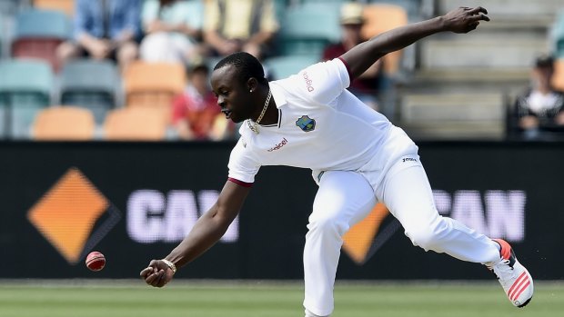 West Indies' bowler Kemar Roach fields off his own bowling against Australia.