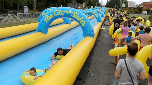 Hundreds of people enjoy the City Slider - a 325m Street Water Slide - in Brisbane
