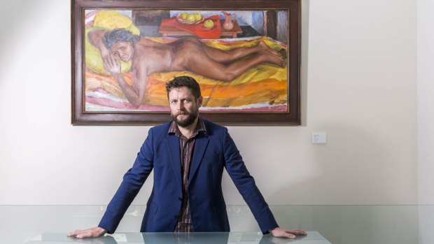 Ben Quilty with a Margaret Olley painting being shown for the first time at Philip Bacon Galleries.
