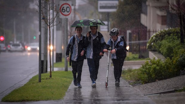 Heavy rain drenches students in Camberwell on Friday afternoon.
