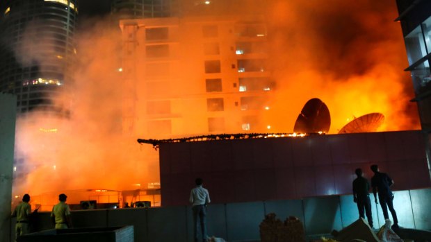 People watch as a huge fire engulfs a rooftop restaurant in Mumbai, India.