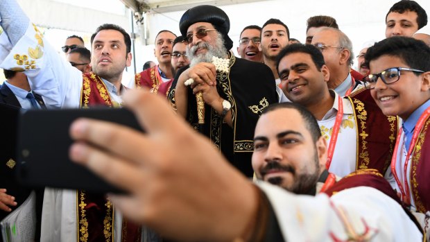 Pope Tawadros II poses for a selfie photograph with deacons from his church after a foundation stone ceremony at the site of the new building and headquarters of his Sydney Diocese.